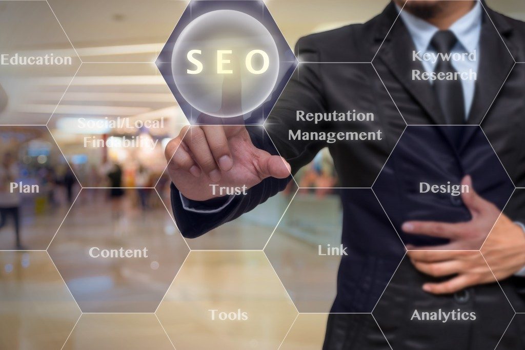 Businessman pointing at holographic SEO words